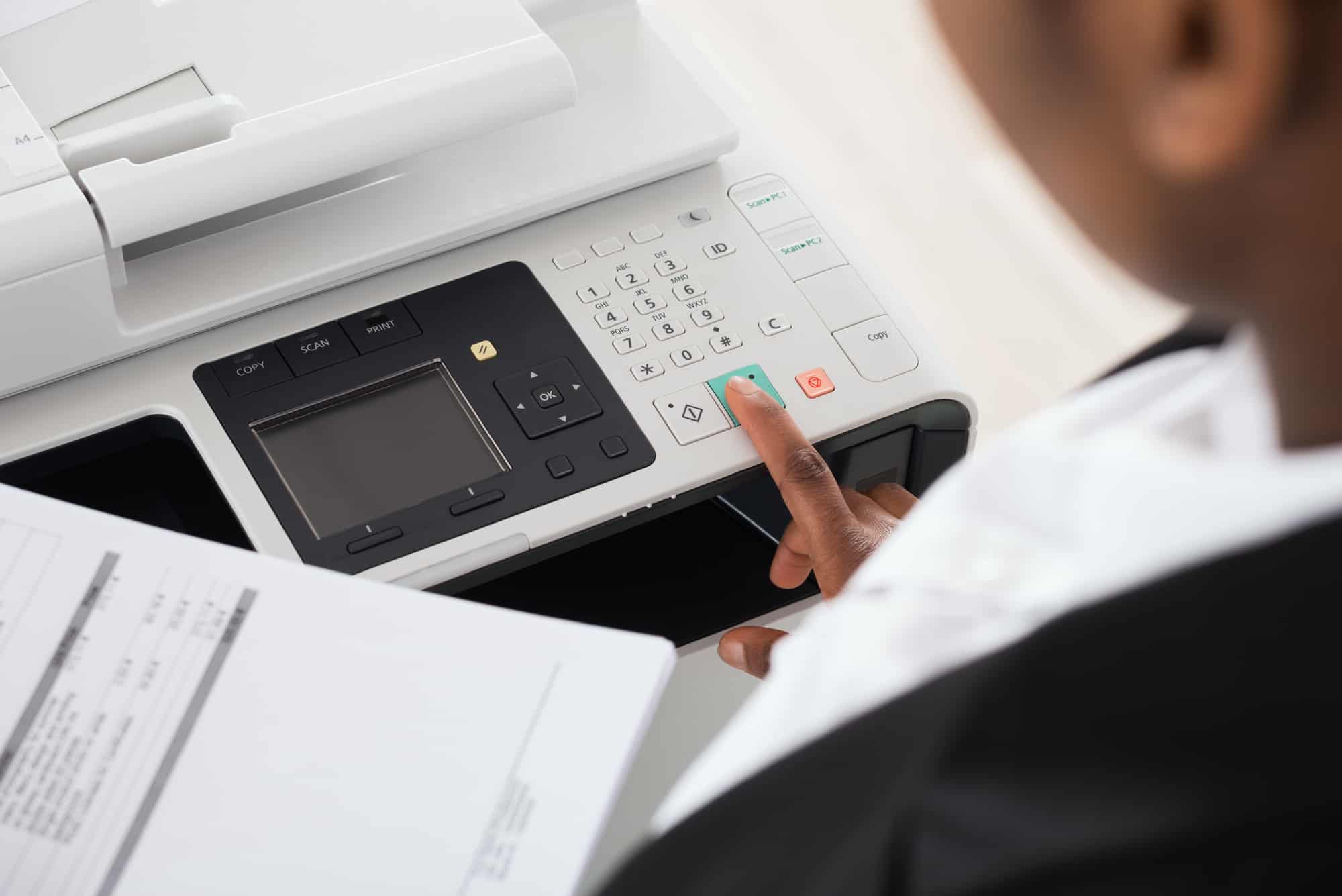 Close-up Of Young Businesswoman Hand Operating Printer In Office