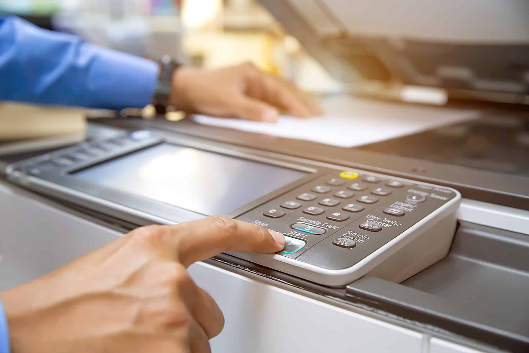 Businessmen press button on the panel for useing photocopier or printer for printout and scanning document paper at office.